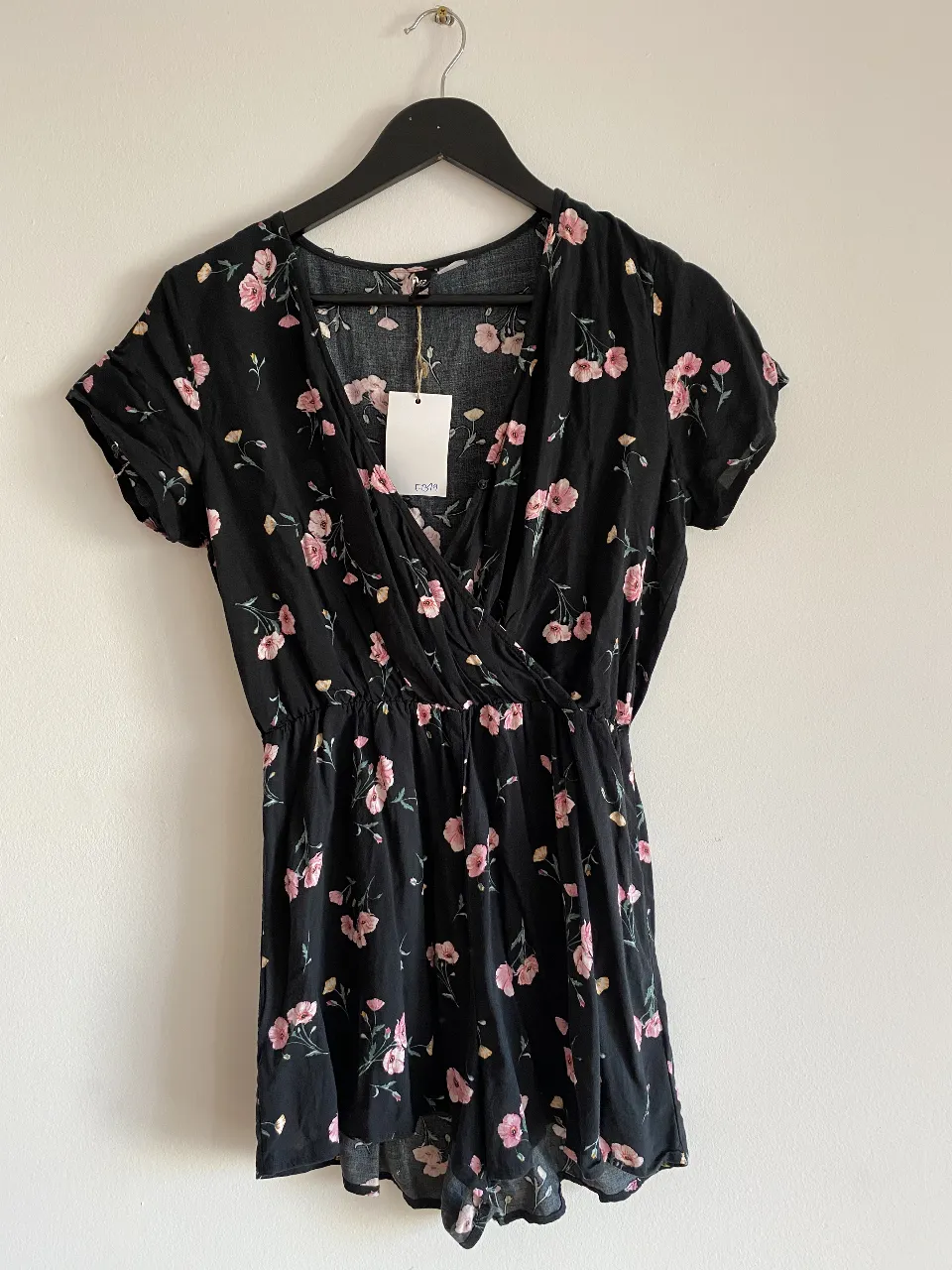 Vestido corto negro con estampado floral rosa, ideal para un look fresco y femenino. Perfecto para salidas casuales o eventos de verano.