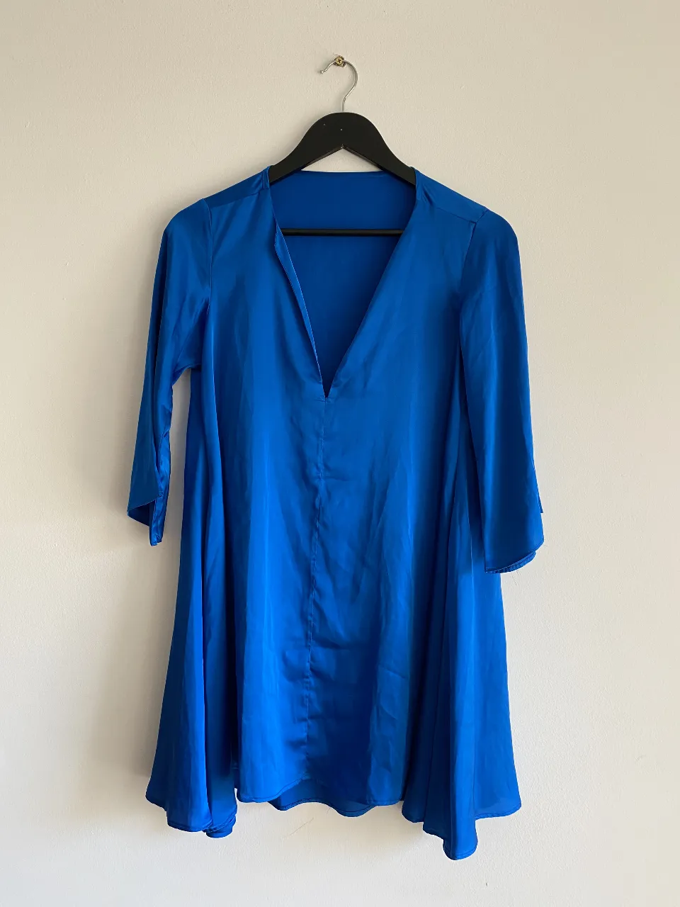 Vestido mini de color azul, con escote en V y mangas 3/4. Ideal para una salida o evento especial.