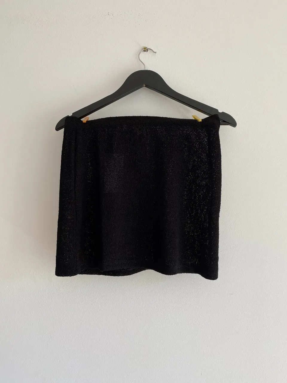 Minifalda negra de tejido brillante, ideal para salidas y eventos especiales. Un básico versátil y elegante para tu guardarropa.