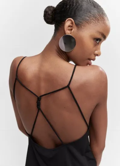 Top negro con espalda descubierta y tiras finas. Ideal para un look moderno y elegante.