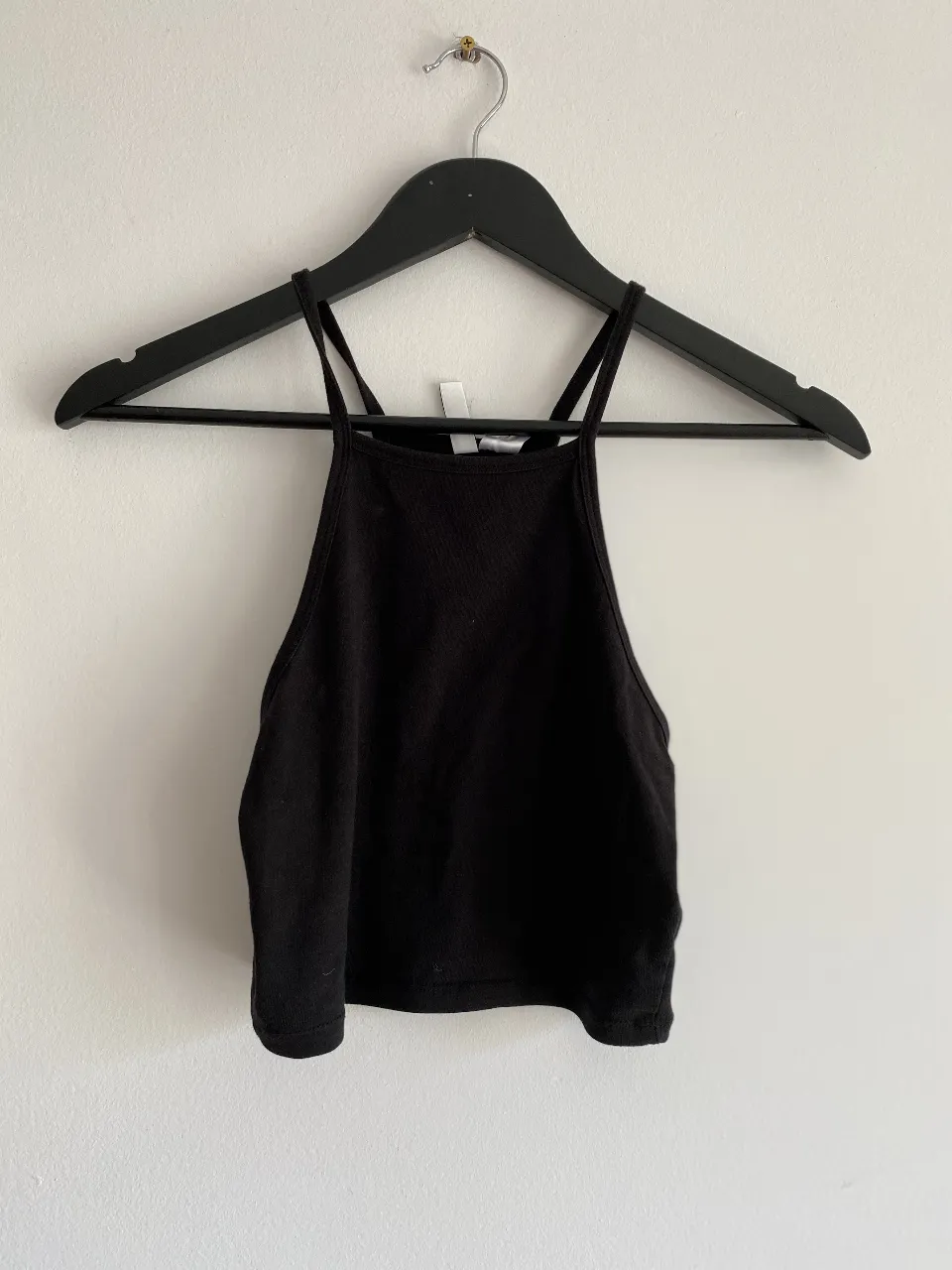 Top negro con breteles finos y corte cuadrado. Ideal para combinar con jeans o faldas.