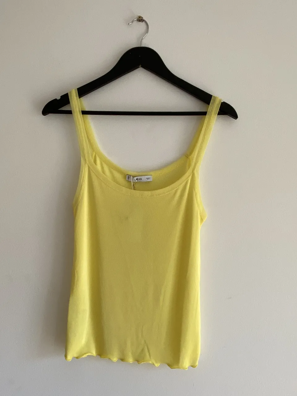 Musculosa amarilla de mujer, ideal para el verano. Confeccionada en tejido suave y ligero, perfecta para combinar con shorts o faldas. Diseño simple y versátil.