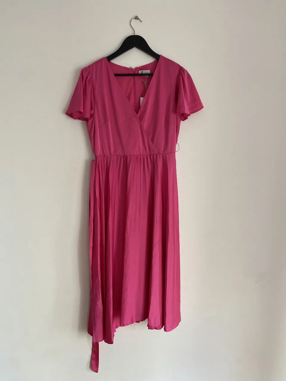 Vestido midi de fiesta en color rosa, con mangas cortas tipo mariposa y corte en la cintura. Diseño elegante y femenino, ideal para eventos especiales.