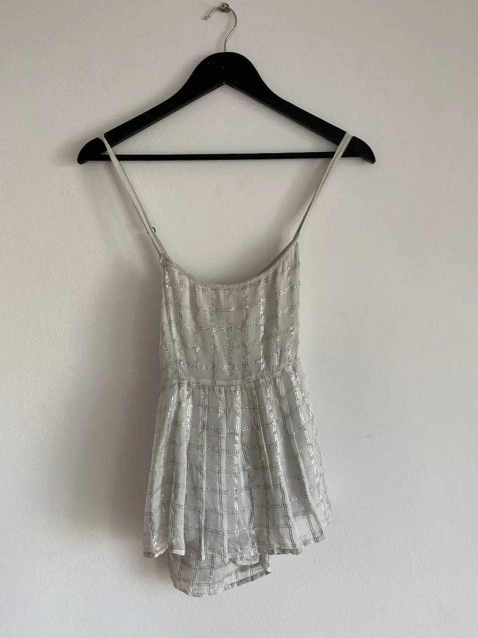 Musculosa con tirantes finos y detalles plateados. Ideal para una fiesta o evento especial.