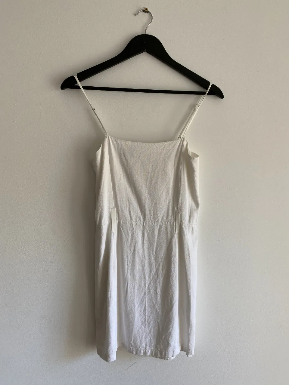 Vestido mini blanco con tirantes finos. Ideal para el verano, este vestido es perfecto para un look casual y fresco. Confeccionado en un tejido ligero y cómodo, este vestido es una opción versátil para cualquier ocasión.
