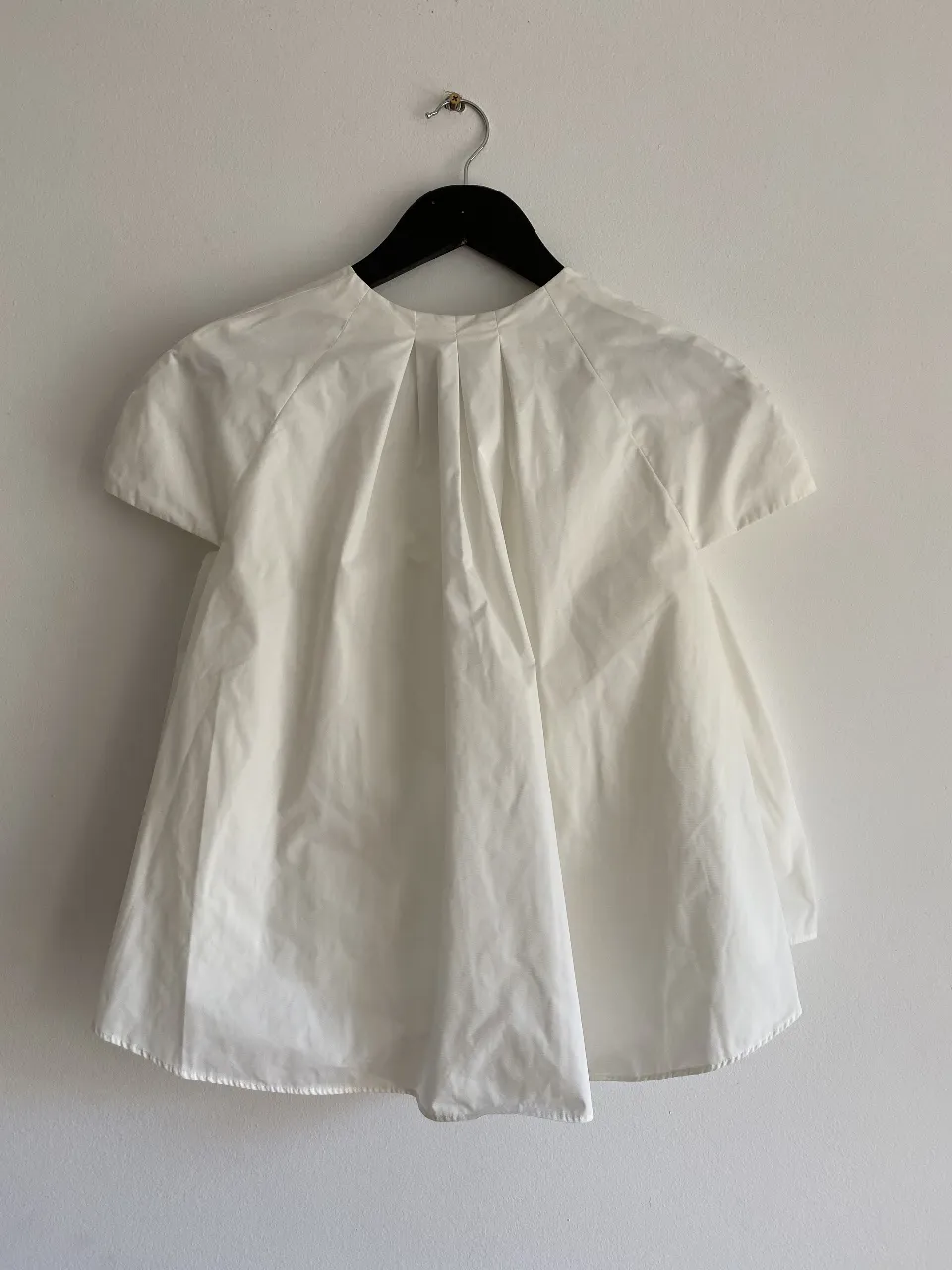 Blusa blanca con diseño holgado y mangas cortas. Ideal para un look fresco y moderno.