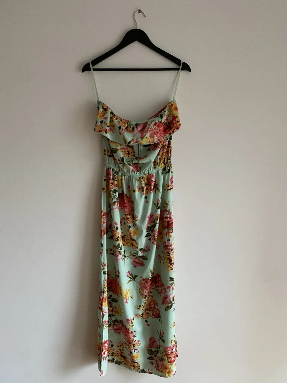 Vestido largo de verano con estampado floral en tonos pastel. Diseño strapless con volados en el busto y cintura elastizada. Ideal para un look fresco y femenino.