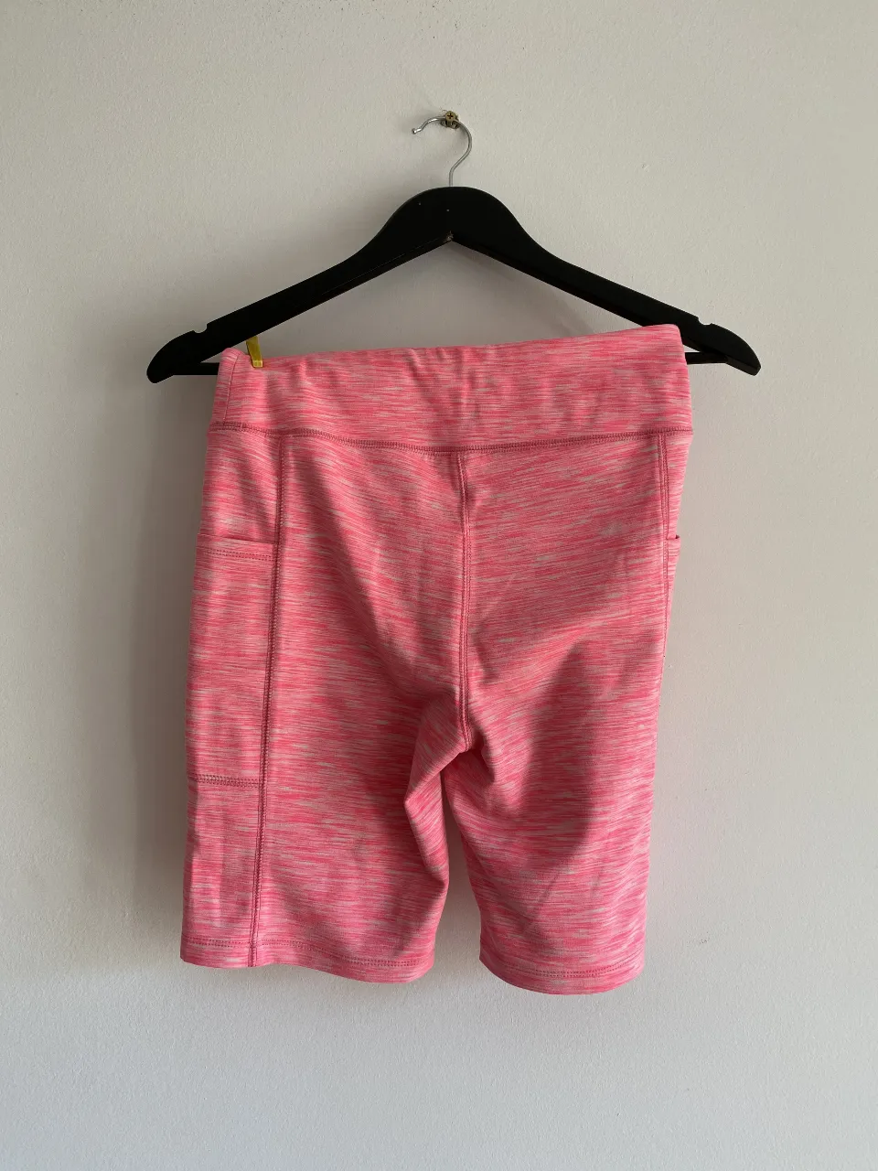 Short deportivo de mujer, color rosa con detalles en blanco. Ideal para actividades físicas.