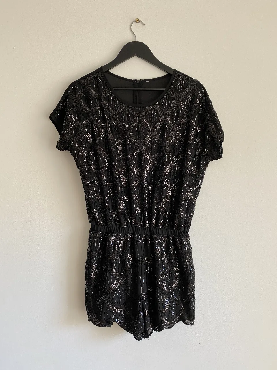 Mono corto de fiesta negro con lentejuelas. Ideal para eventos especiales y salidas nocturnas. Diseño elegante y moderno.