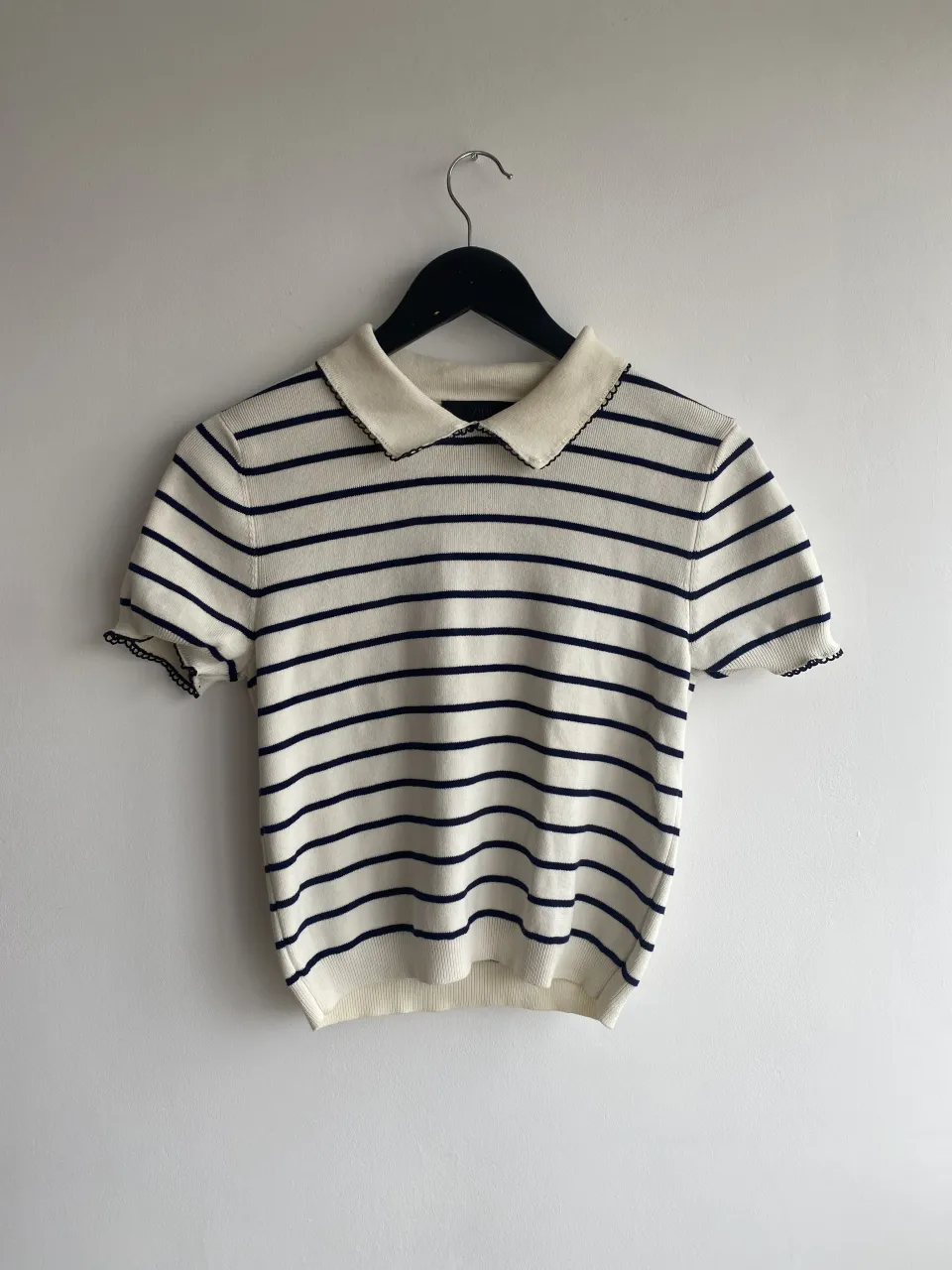 Remera a rayas blanca y azul marino, con cuello polo y mangas cortas. Un clásico que no puede faltar en tu guardarropa.
