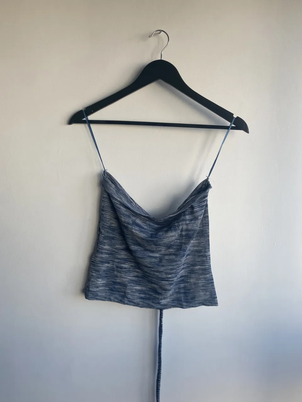 Top de tejido jaspeado en tonos azules y blancos. Posee tiras finas para atar en la nuca y una tira larga que se ata en la cintura.