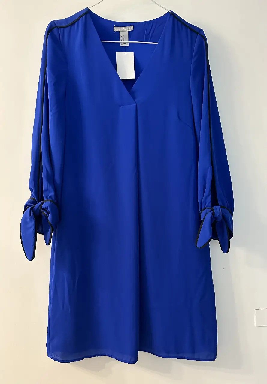 Vestido midi azul con mangas largas y detalles en negro. Se puede usar también como camisa larga. Largo total 90 cm. Forrado con satén del mismo color. Ideal para un look elegante y versátil.