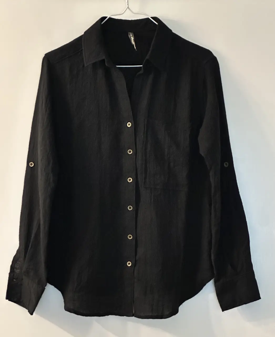 Camisa negra de manga larga con botones y bolsillo en el pecho. tela símil bambula. Espalda 40 cm, mangas 56,5 cm, ancho 45 cm. Ideal para un look casual y versátil. 