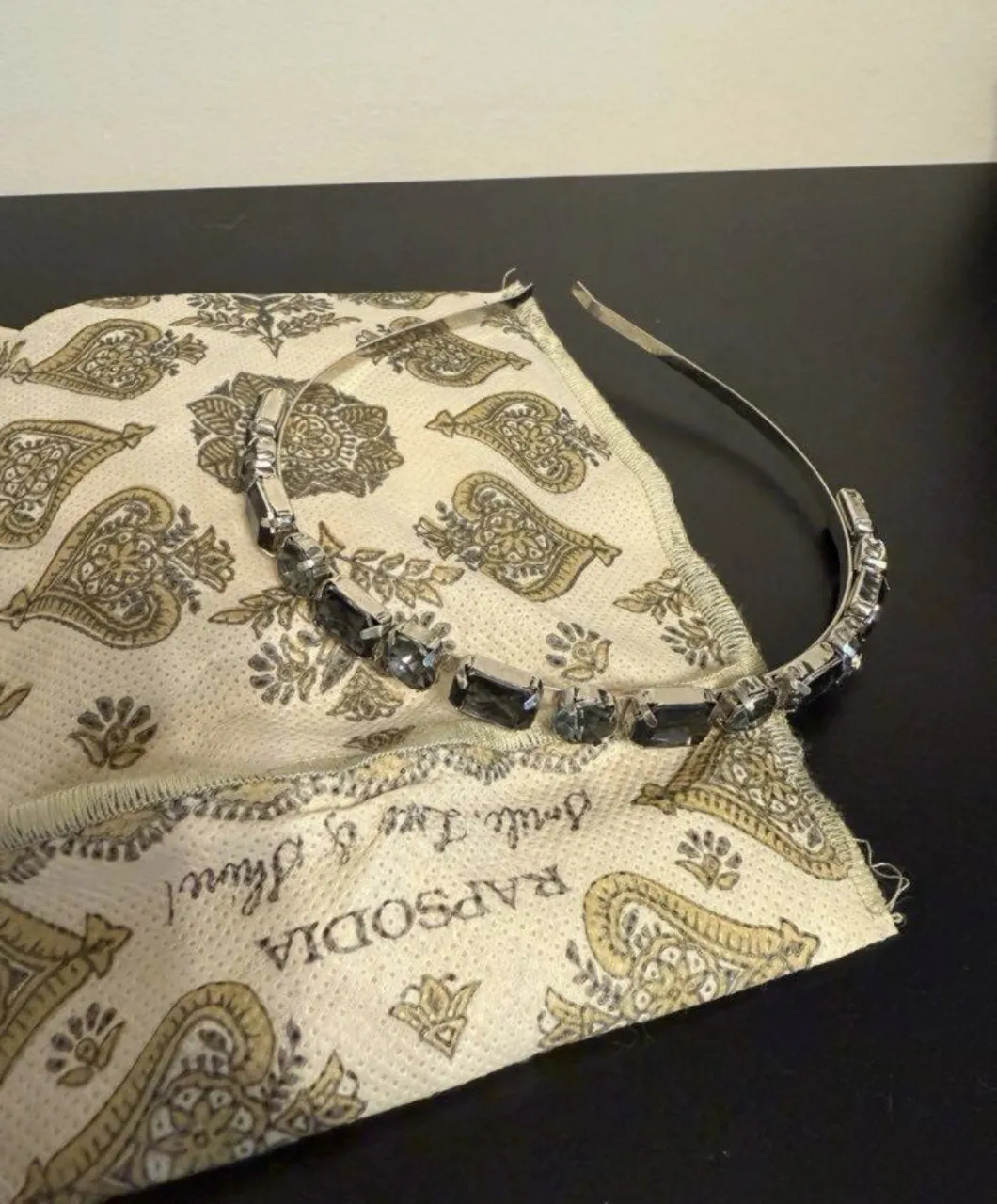 Vincha plateada con piedras grises rectangulares, ideal para darle un toque de brillo a tu look.