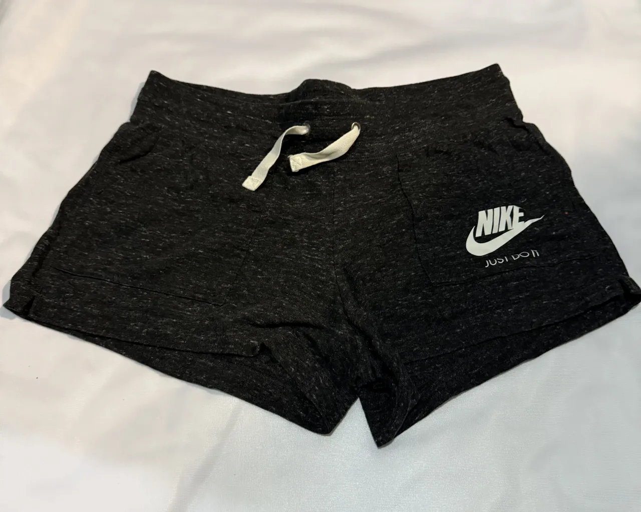 Shorts deportivos Nike grises jaspeados con cordón blanco y logo blanco. Ideales para entrenar o para un look casual y cómodo. nuevo sin etiqueta. original 