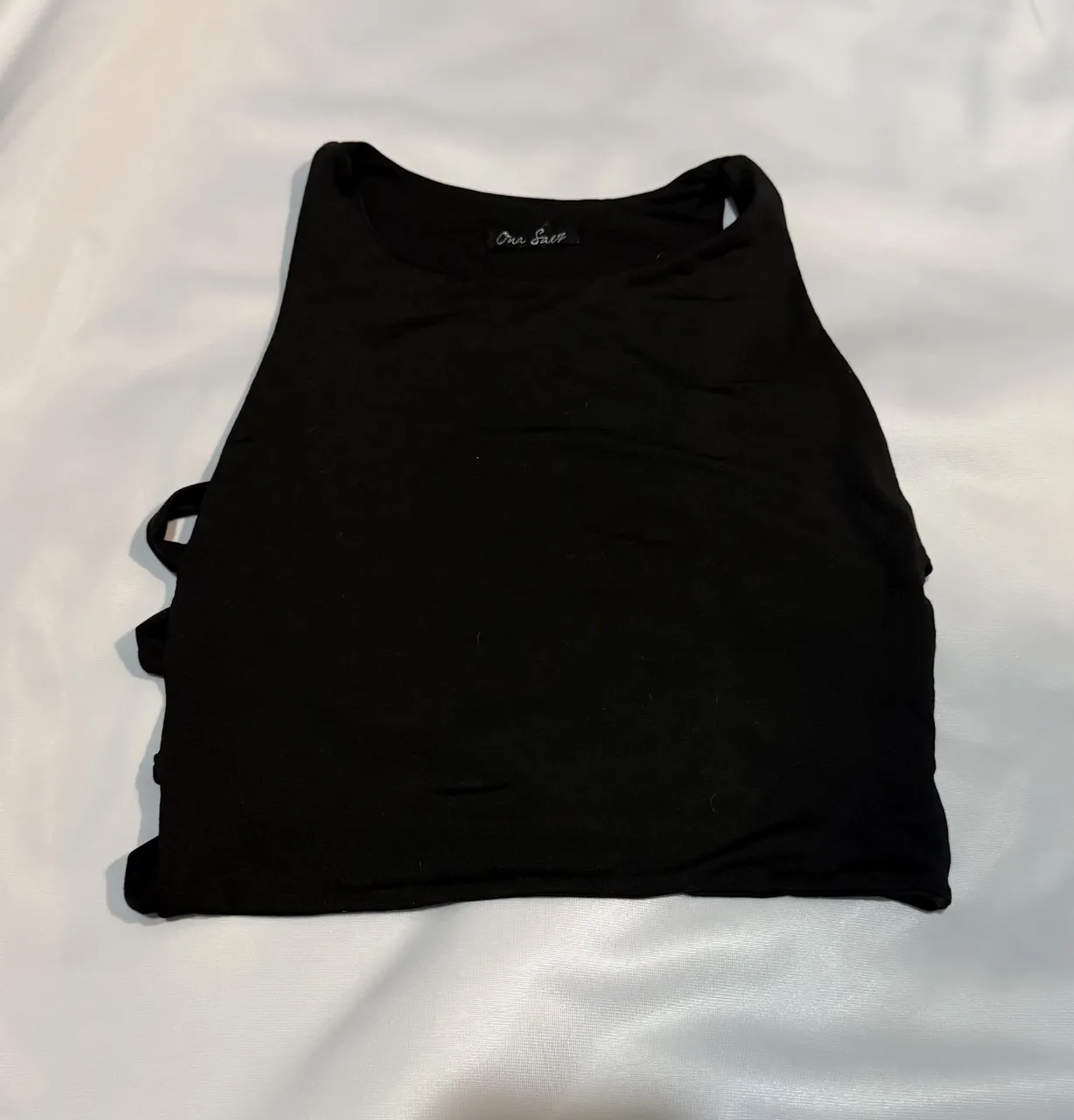 Musculosa negra con recortes laterales, ideal para un look canchero y moderno. Perfecta para combinar con jeans o shorts. de lycra súper elastizada 