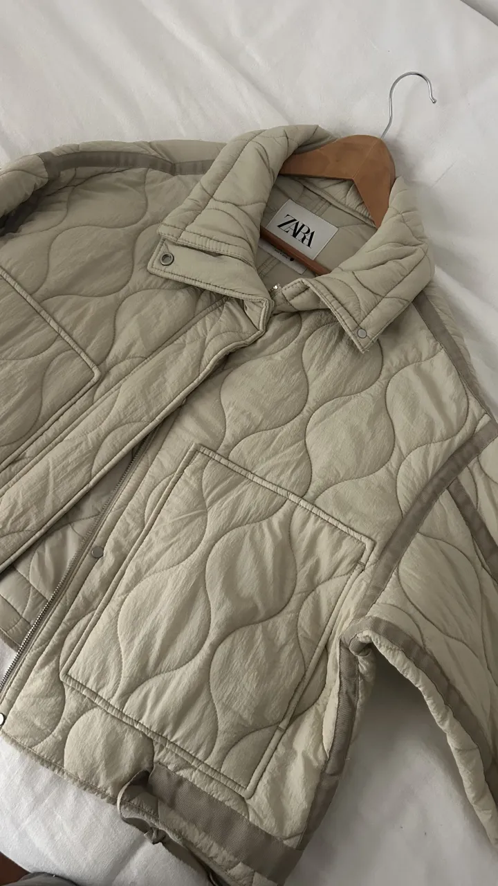 Campera Zara acolchada color crudo con cuello  y bolsillos frontales. Cierre metálico. Elástico en la cintura. 2 usos