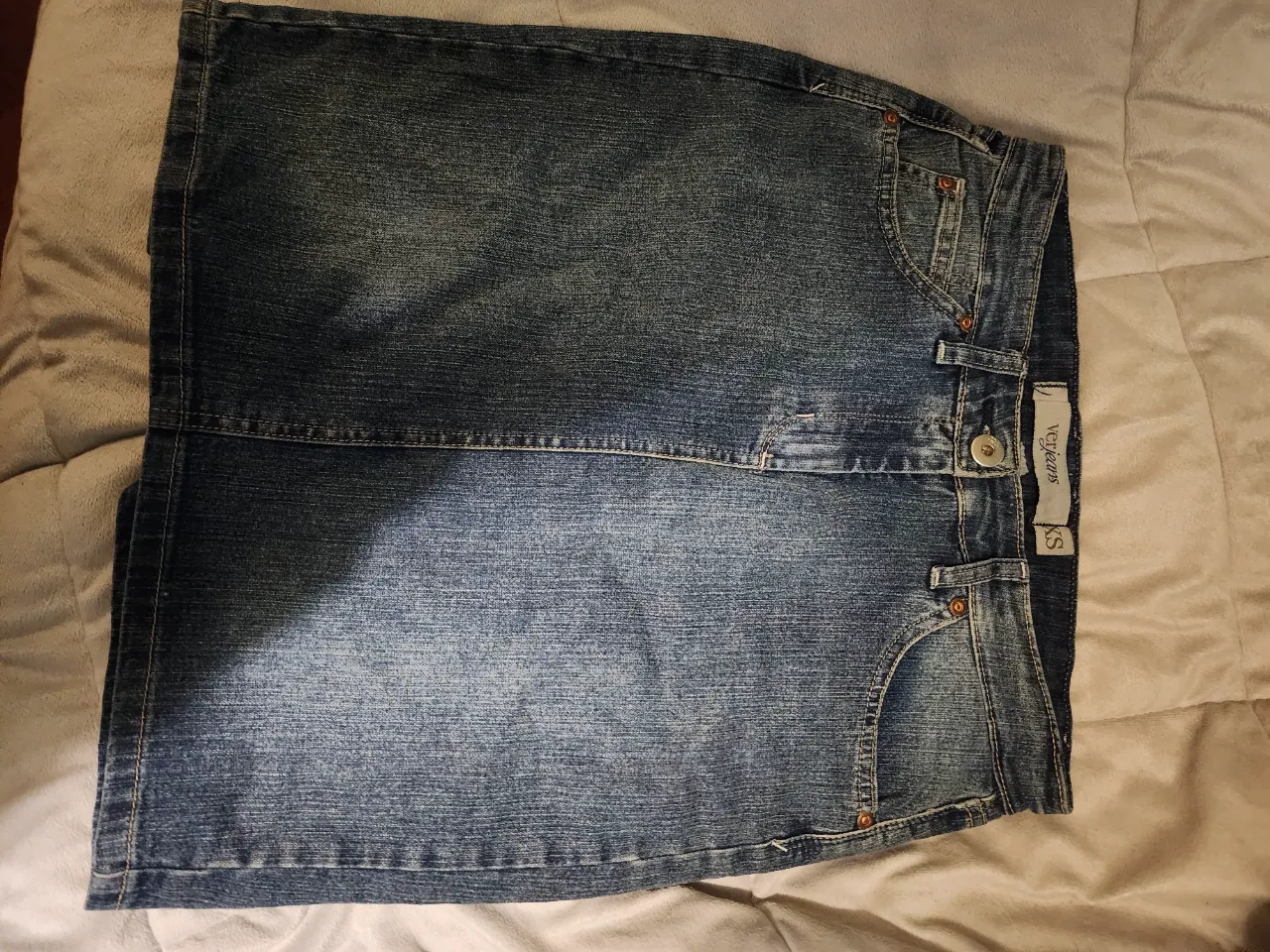 Pollera de jean tiro alto/medio, con bolsillos delanteros y traseros. tajo atras.  Ideal para un look casual y cómodo.