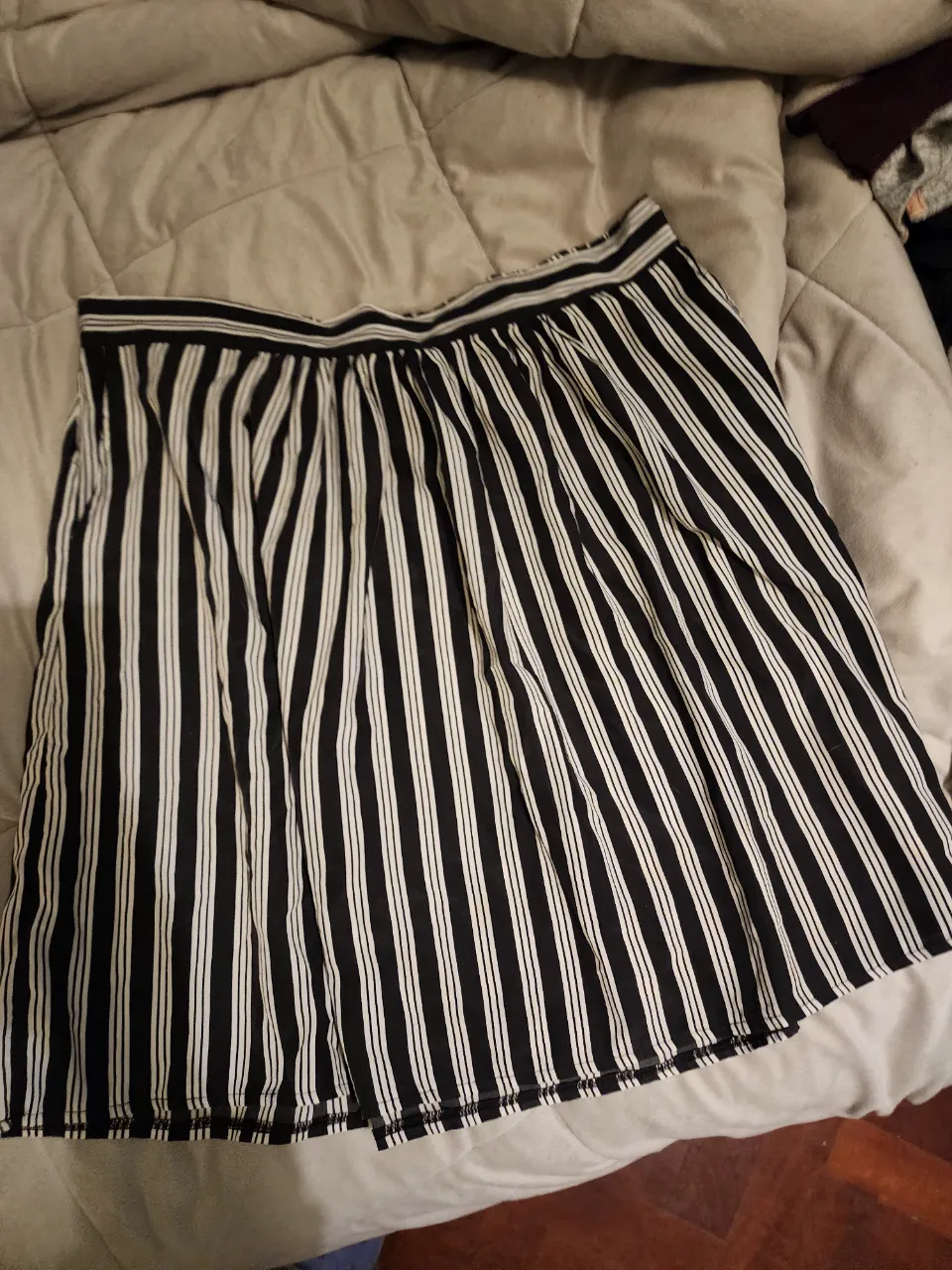 Pollera por encima de la rodilla, a rayas verticales en blanco y negro, ideal para un look casual y fresco. Confeccionada en tela liviana y cómoda, perfecta para combinar con diferentes tops y crear outfits versátiles. Con bolsillo y cadera ajustable.