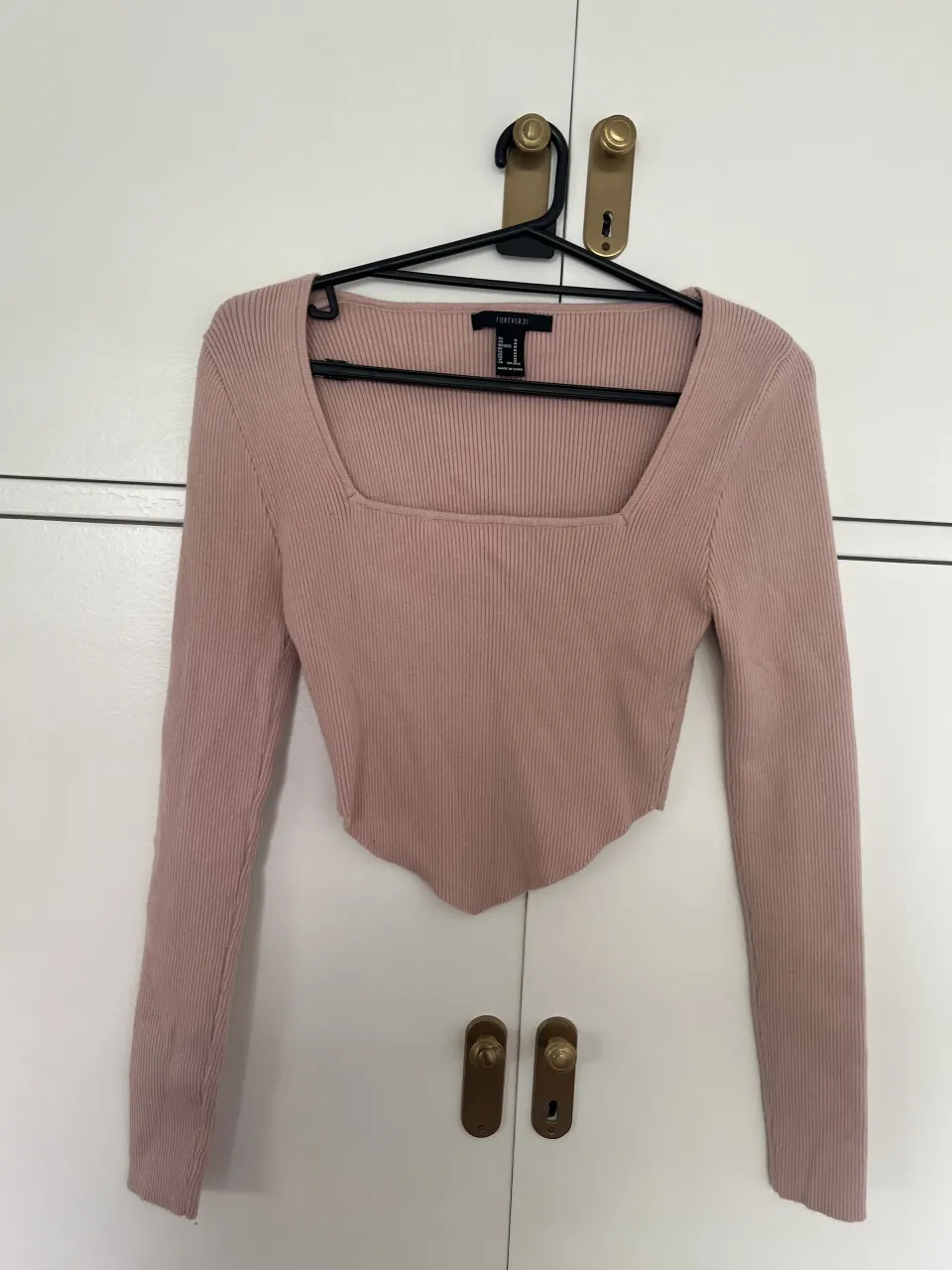 Remera manga larga de tejido de punto acanalado, con escote cuadrado y tajos irregulares en la parte inferior.