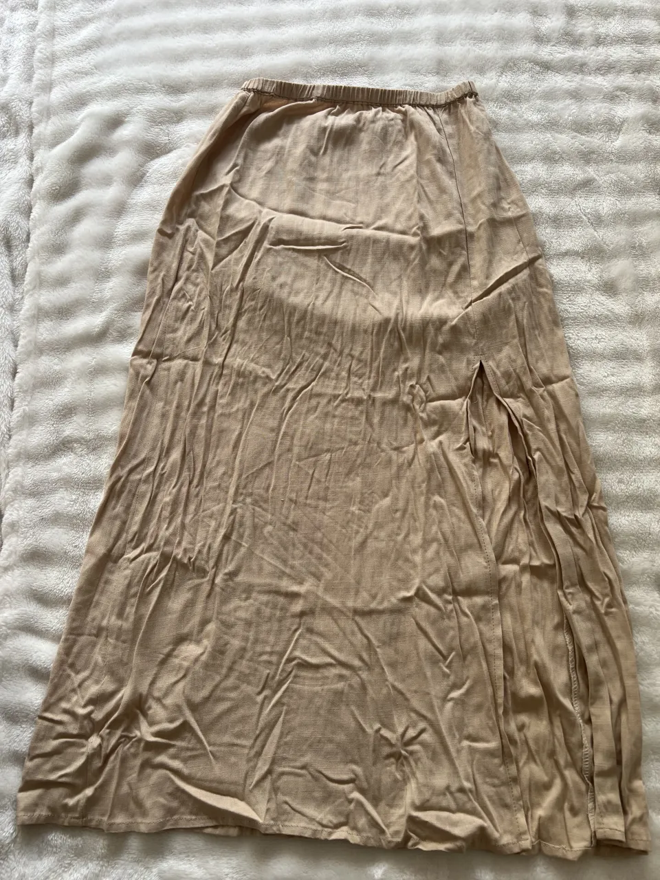 Pollera larga de color beige con abertura lateral. Cintura elastizada.