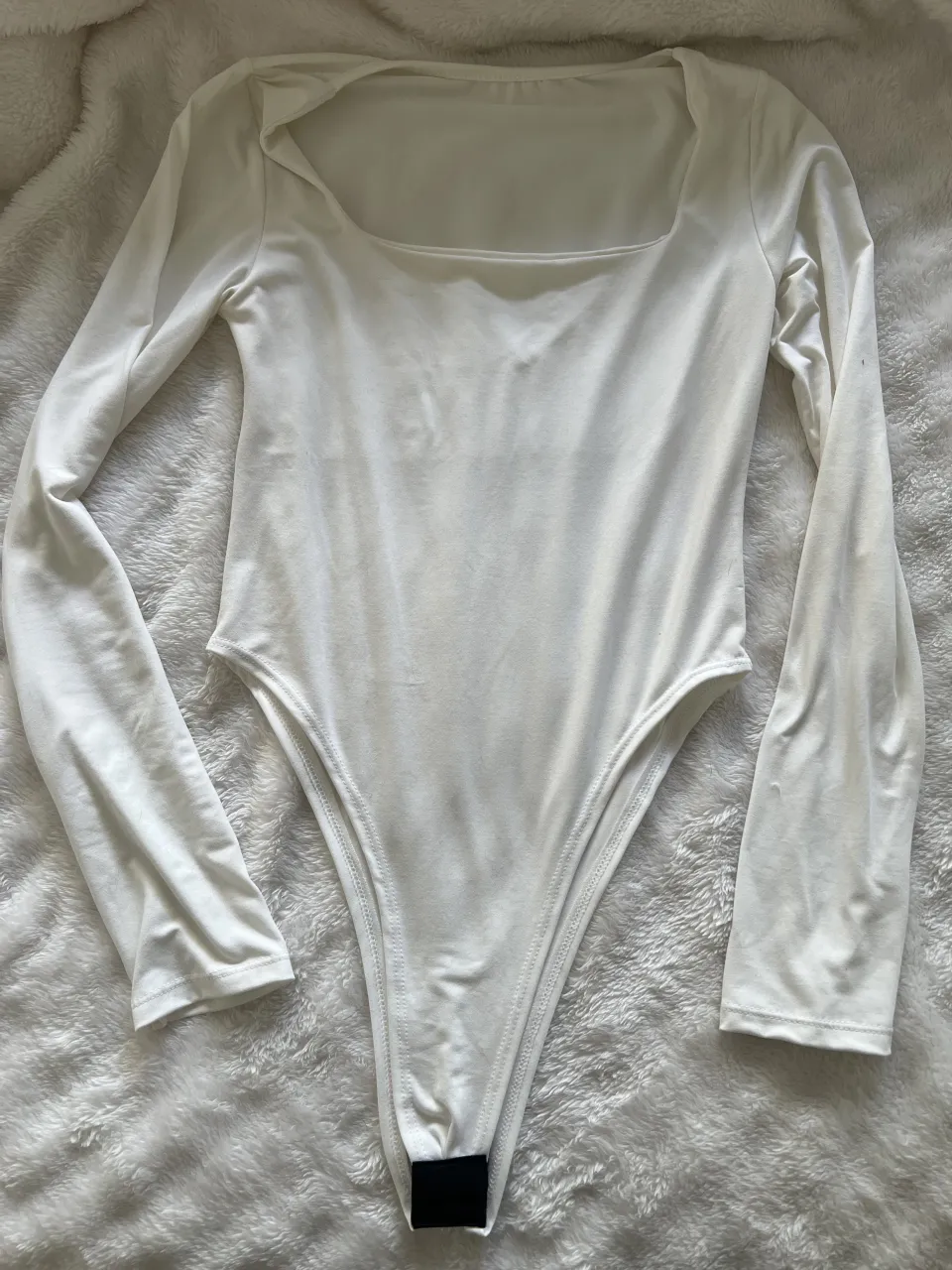 Body blanco de manga larga con escote cuadrado. Un básico súper versátil para armar looks cancheros.