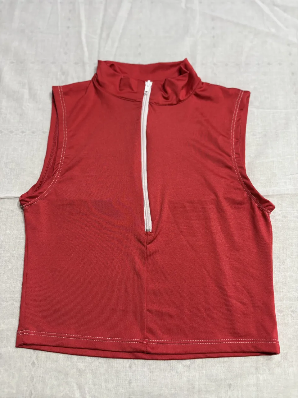 Top sin mangas rojo con cierre al cuello. Ideal para un look casual y moderno.