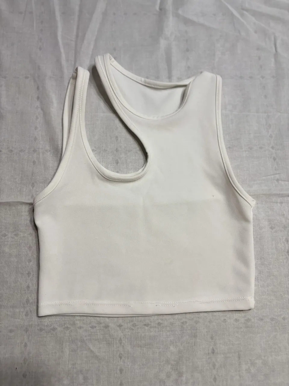 Top blanco escotado con diseño asimétrico. Ideal para un look moderno y canchero.