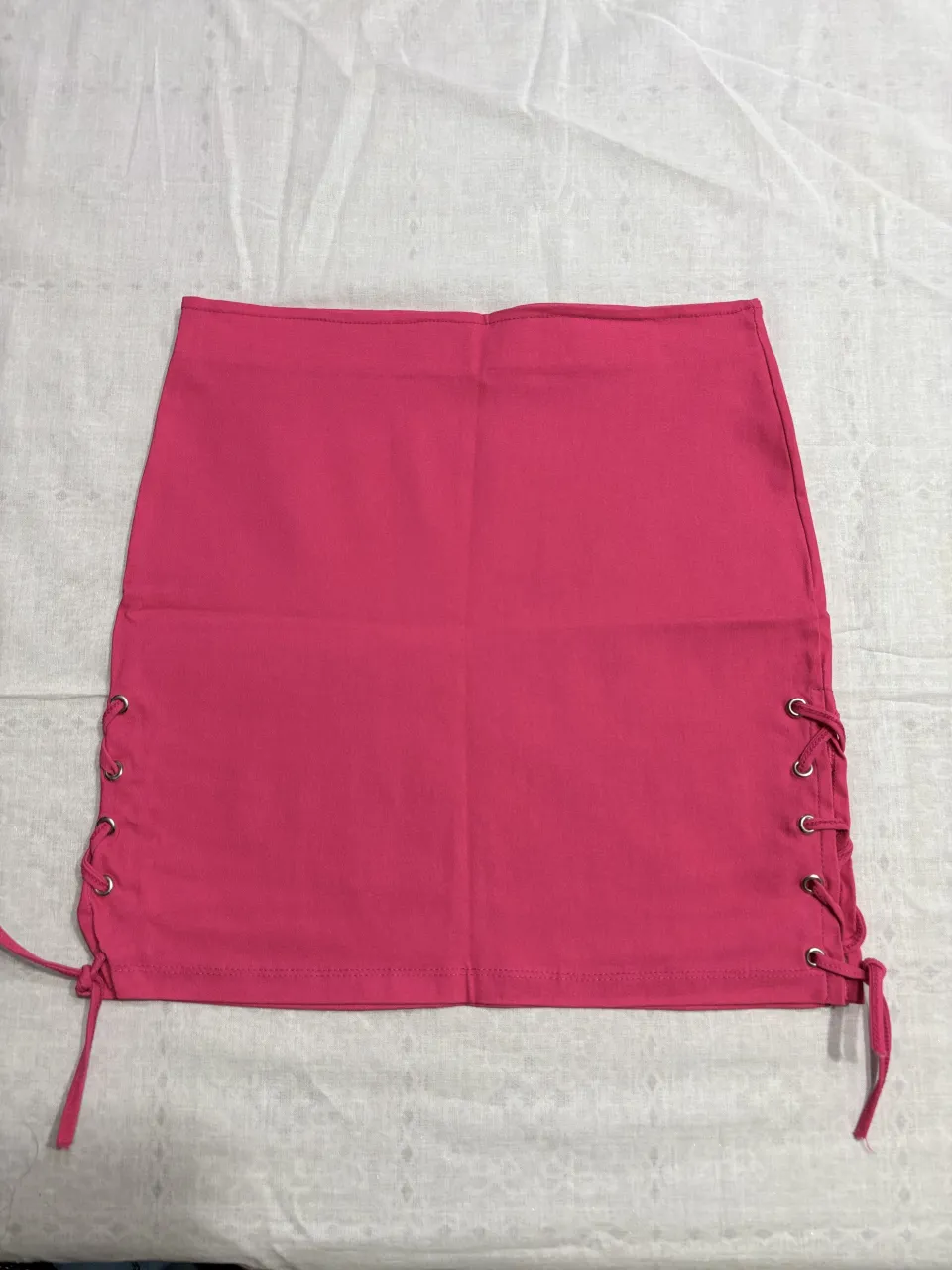 Pollera corta tiro alto, elastizada, súper canchera, ideal para el verano o una salida. Tiene detalles de cordones en los laterales que le dan un toque único y ajustable. ¡No te la pierdas!