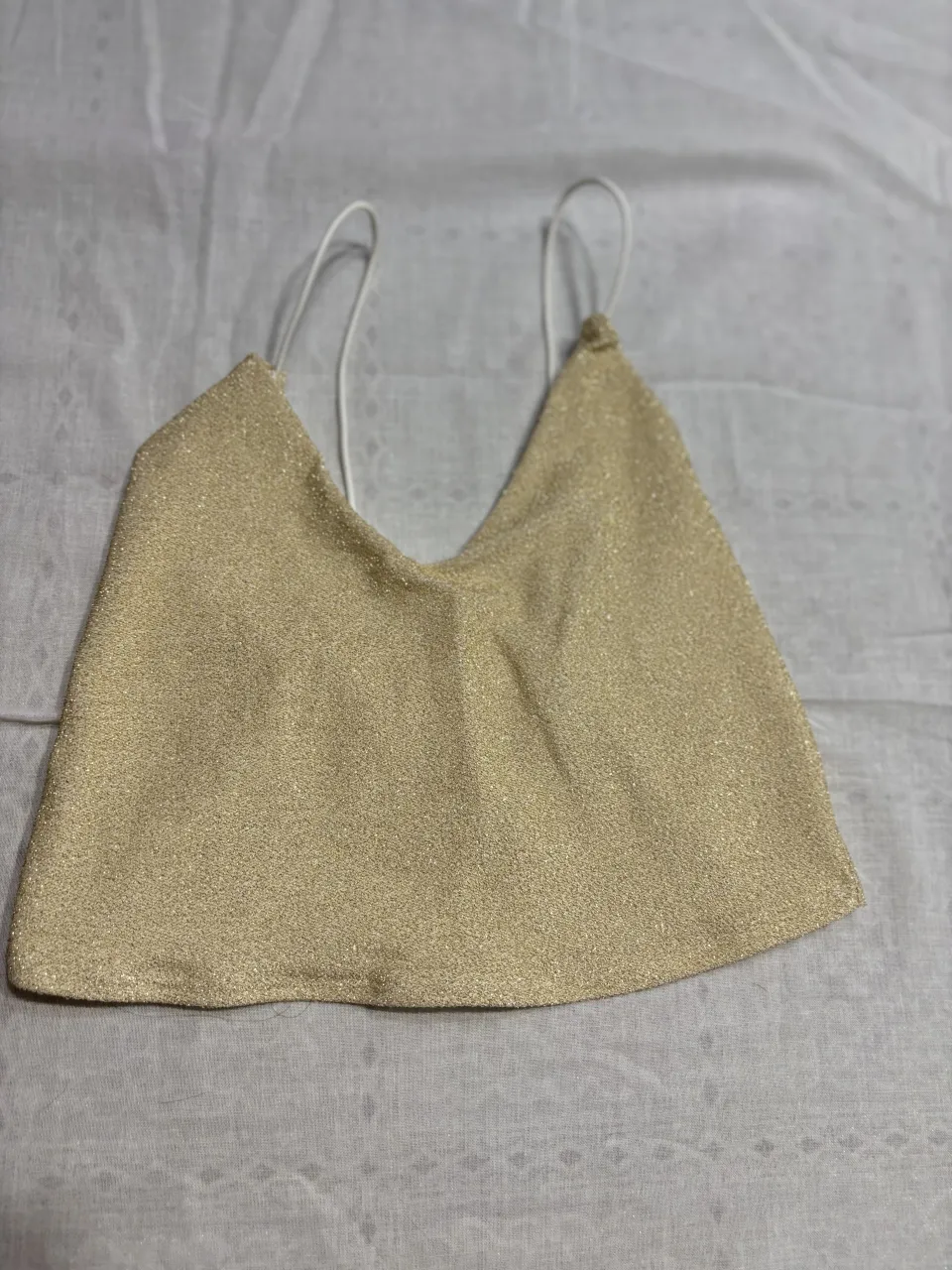 Top dorado con brillos, ideal para fiestas o salidas nocturnas. Su diseño moderno y llamativo lo convierte en una pieza clave para un look canchero y a la moda.