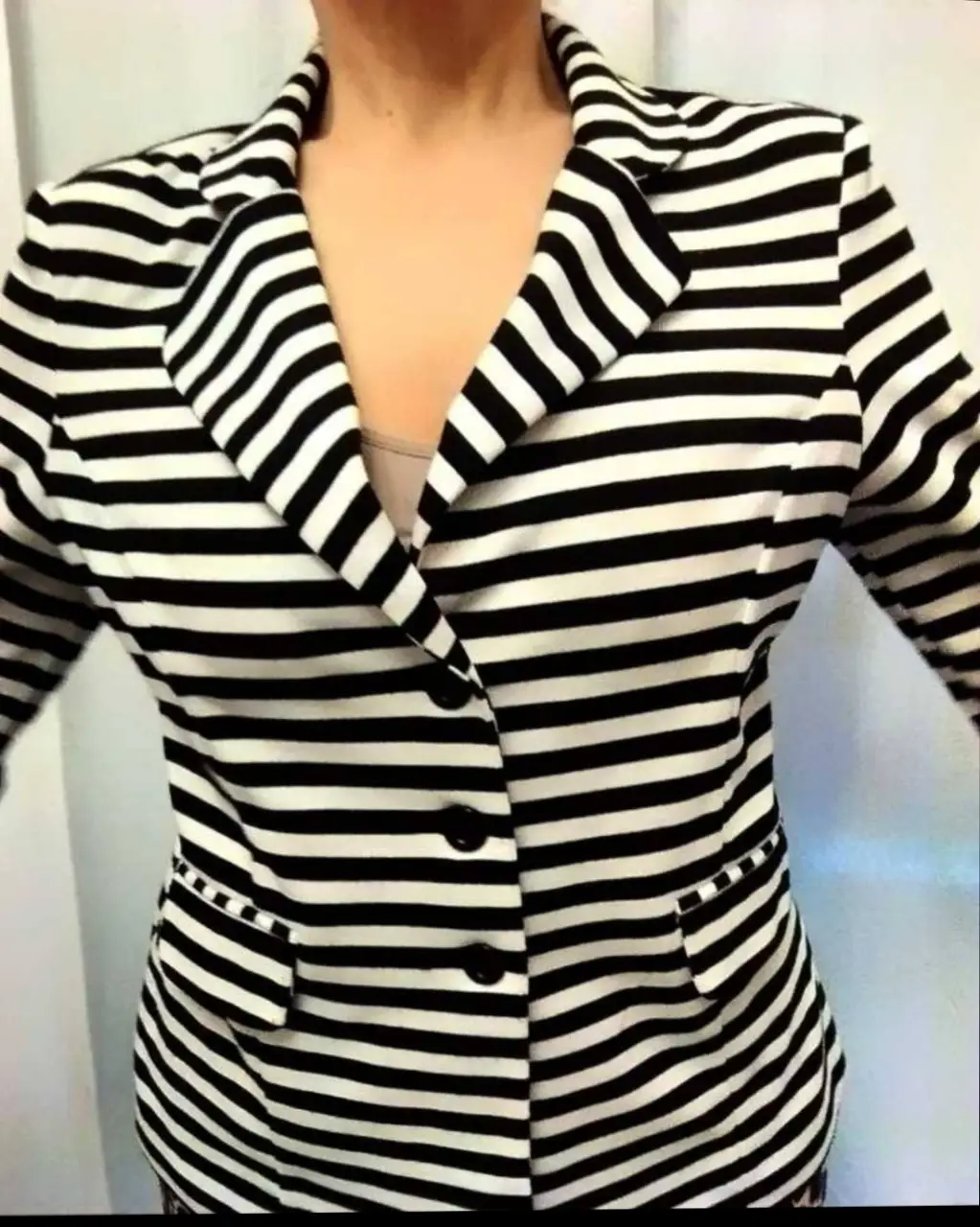 Blazer a rayas blanco y negro, con botones y bolsillos. Ideal para un look elegante y moderno. importado sin uso 