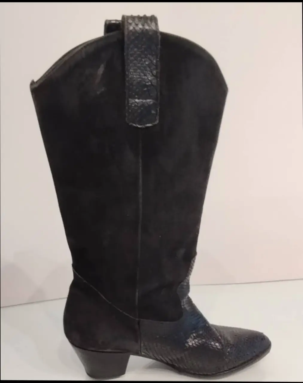 Botas de caña alta negras, con detalles de cuero reptil en la puntera y el talón. Ideales para un look audaz y sofisticado.