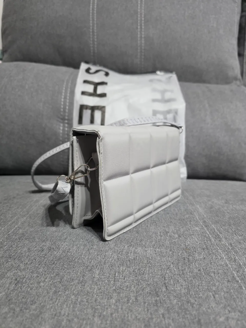 Cartera gris acolchada, súper canchera y moderna. Ideal para llevar tus esenciales con estilo. Cierre magnético.