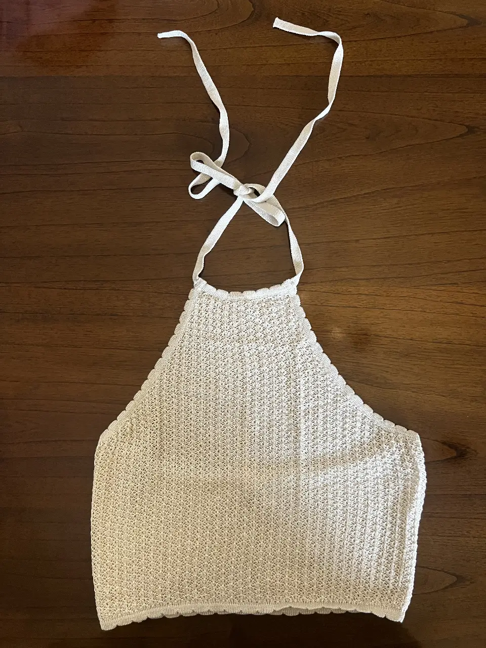 Top halter tejido en color blanco, ideal para un look fresco y veraniego. Perfecto para combinar con shorts o faldas.