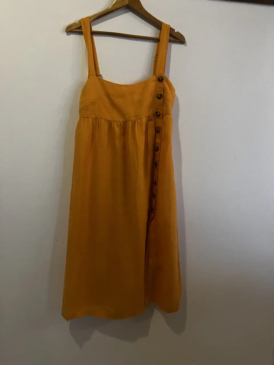 Vestido midi de tirantes con botones laterales. Ideal para un look casual y fresco.