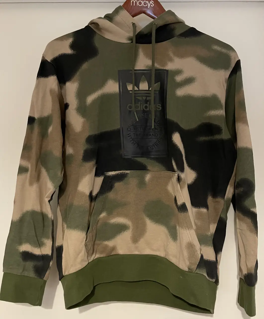 Buzo canguro Adidas con estampado camuflado. Ideal para un look urbano y deportivo. Confeccionado en algodón, este buzo ofrece comodidad y estilo.