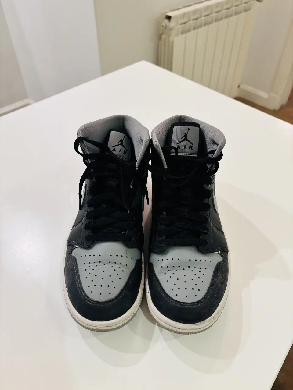 Zapatillas Air Jordan 1 Mid, color negro y gris, ideales para un look urbano y deportivo. Diseño icónico y cómodo para el día a día.