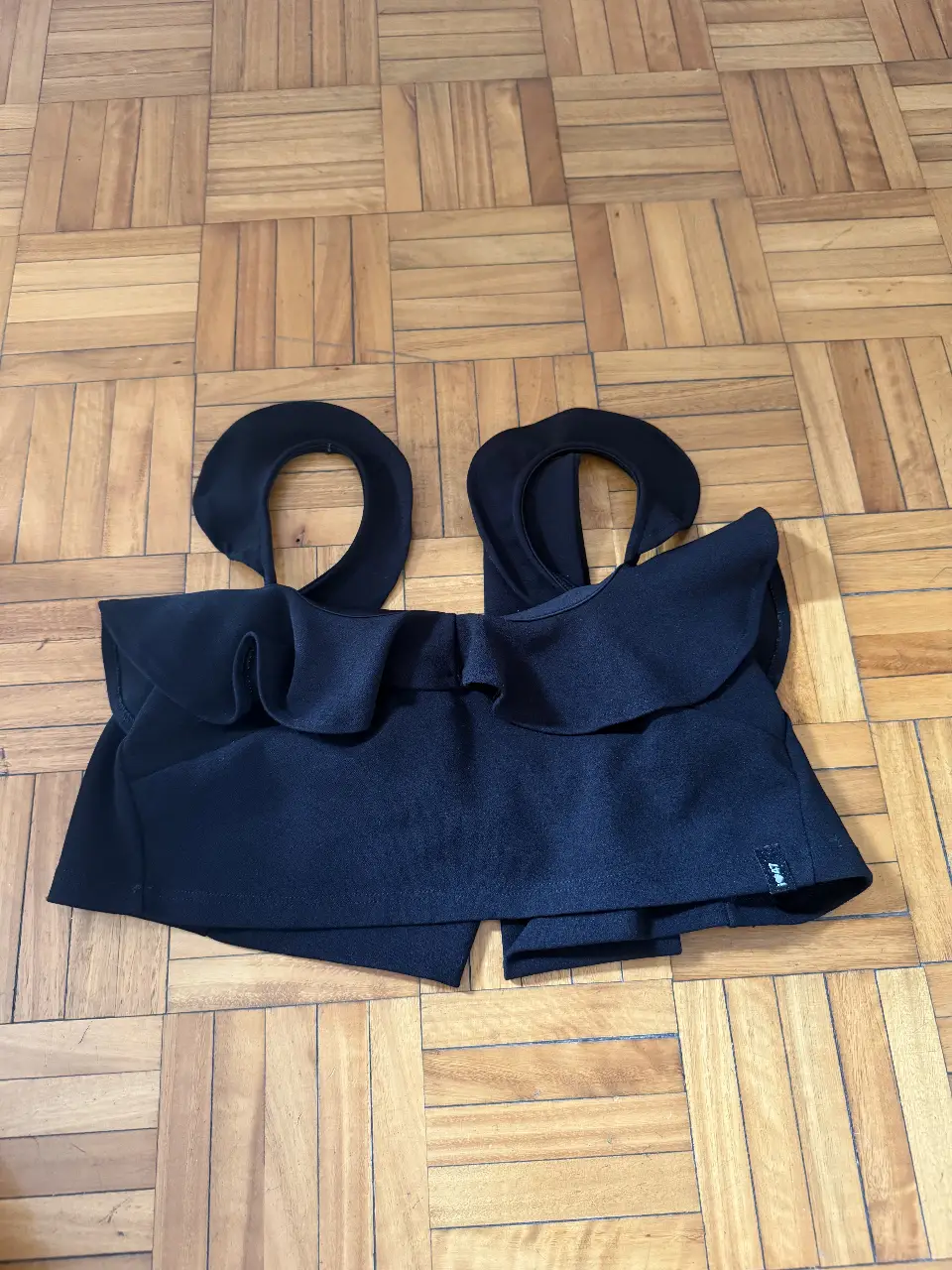 Top negro con diseño de volados y tiras para atar. Ideal para un look de fiesta o salida.