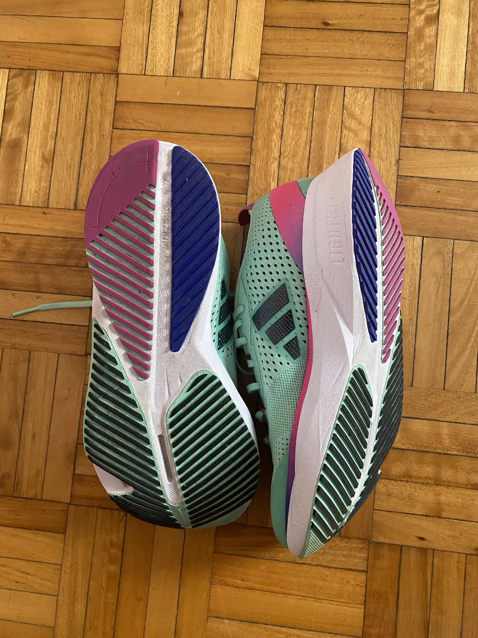 Zapatillas Adidas Adizero SL para running en color verde menta con detalles en rosa y violeta. Talle 8 US. Ideales para tus entrenamientos y carreras.
