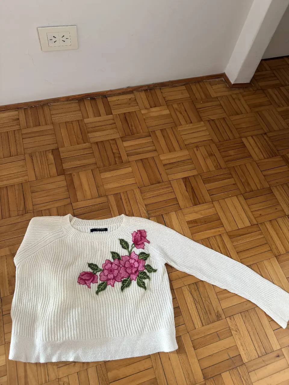 Sweater blanco de punto con bordado floral en tonos rosas y verdes. Ideal para un look casual y femenino.