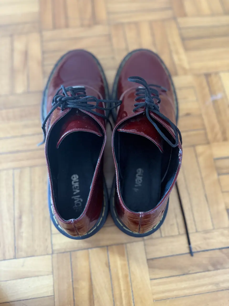 Borcegos de charol color bordó, con cordones negros y suela negra. Estilo clásico y elegante, ideales para un look moderno y sofisticado.