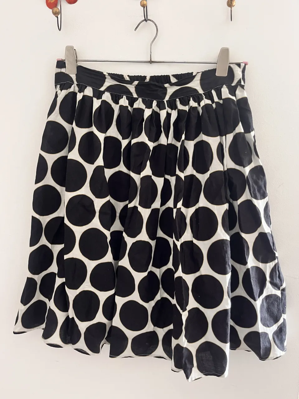 Pollera corta con estampa de lunares grandes en blanco y negro.