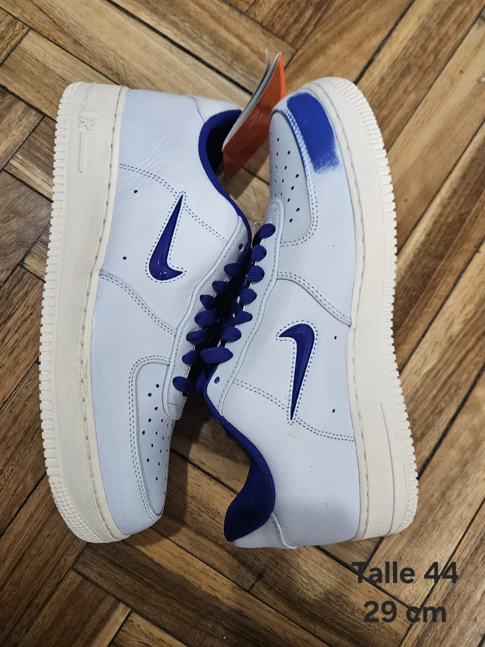 Zapatillas Nike Air Force 1 blancas con detalles en azul. Talle 44, 29 cm. Ideales para un look casual y urbano.
