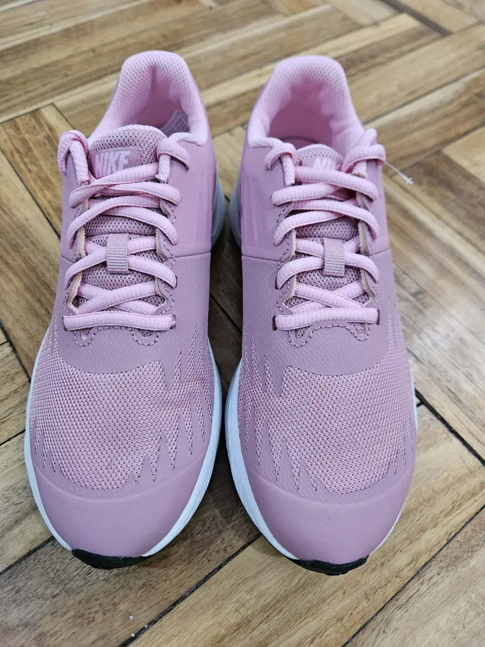Zapatillas Nike para mujer, color rosa con detalles en blanco y suela negra. Talle 35.5, ideales para running y uso diario.