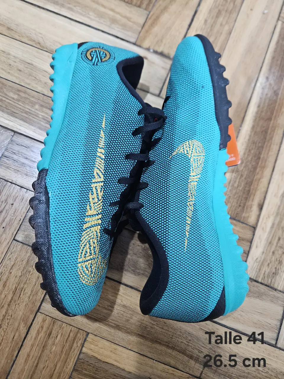 Zapatillas de fútbol para hombre, color turquesa con detalles dorados y negro. Talle 41, 26.5 cm. Ideales para jugar en cancha de césped sintético.