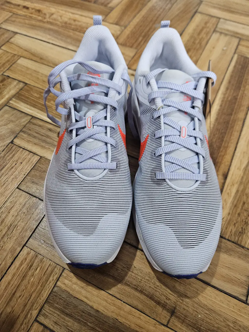 Zapatillas Nike para hombre, color gris con detalles en naranja. Talle 41.5 (27 cm). Ideales para running y entrenamiento.