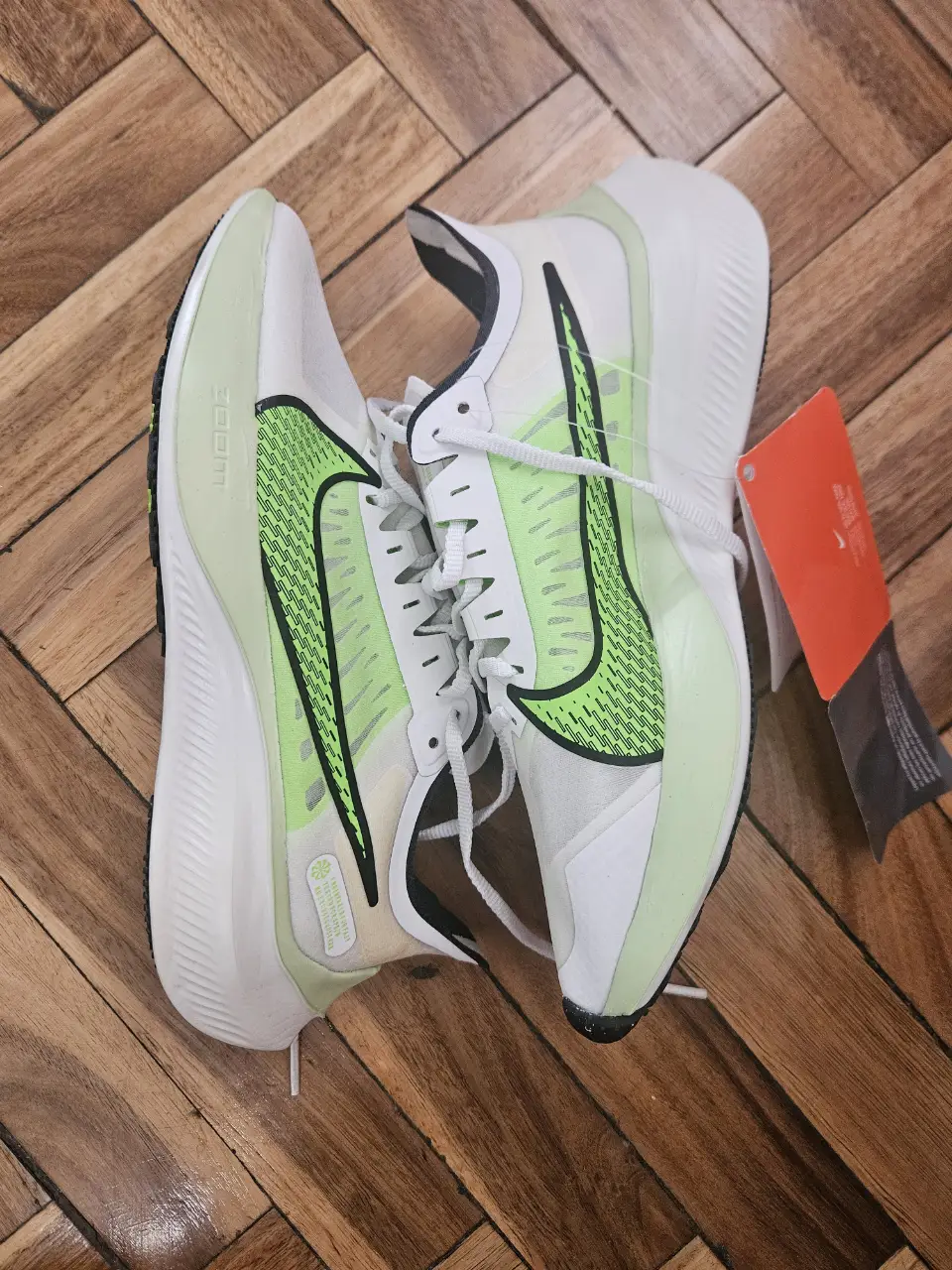 Zapatillas Nike Zoom Gravity, blancas con detalles en verde y negro. Ideales para running y entrenamiento.