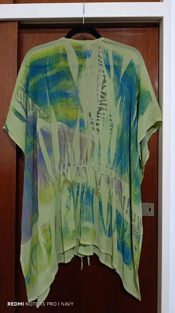 Kimono de playa con estampado abstracto en tonos verdes y azules. Ideal para un look bohemio y fresco en verano. Con ajuste en la cintura y mangas amplias.