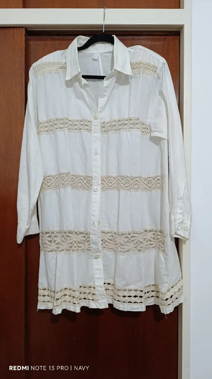 Camisa blanca de mujer con detalles de encaje. Diseño elegante y femenino, ideal para un look casual o semi-formal. Confeccionada en tela ligera y fresca, perfecta para el verano. Detalles de encaje en el frente y en el borde inferior.