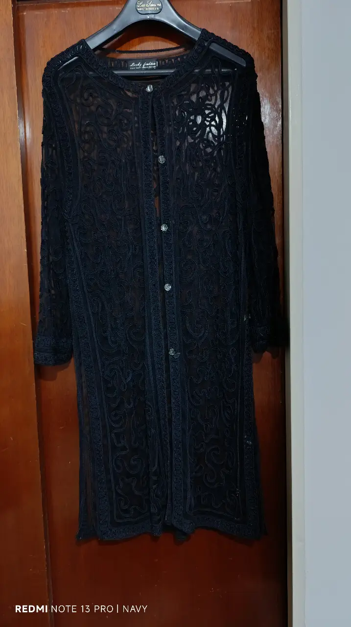 Elegante vestido largo de encaje negro, ideal para eventos formales o fiestas. Diseño con botones frontales y detalles intrincados de encaje que añaden un toque sofisticado y femenino. Perfecto para lucir un look sofisticado y con estilo.